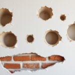 Duże ubytki w ścianie przed naprawą - widoczne głębokie uszkodzenia wymagające profesjonalnej naprawy